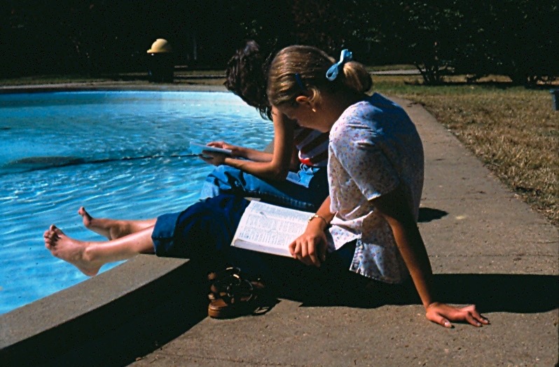 Photo of two students sitting by a fountain.